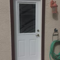Two panel metal door with mini blinds
